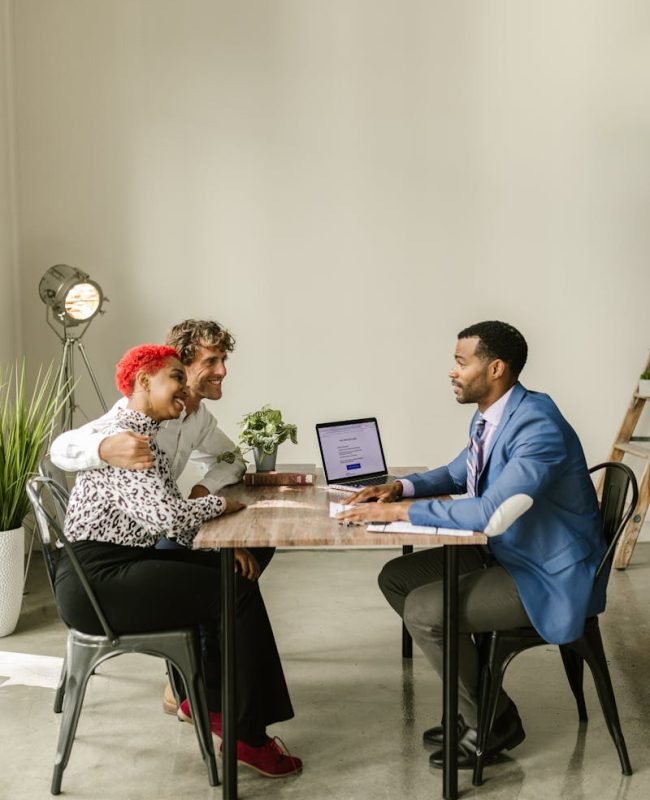 Photo by RDNE Stock project A professional financial advisor discusses options with a couple in a modern office setting.